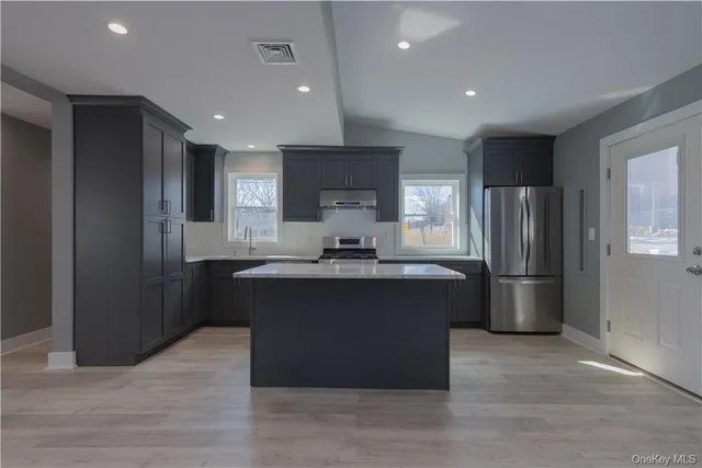 a kitchen with stainless steel appliances granite countertop a refrigerator and a stove