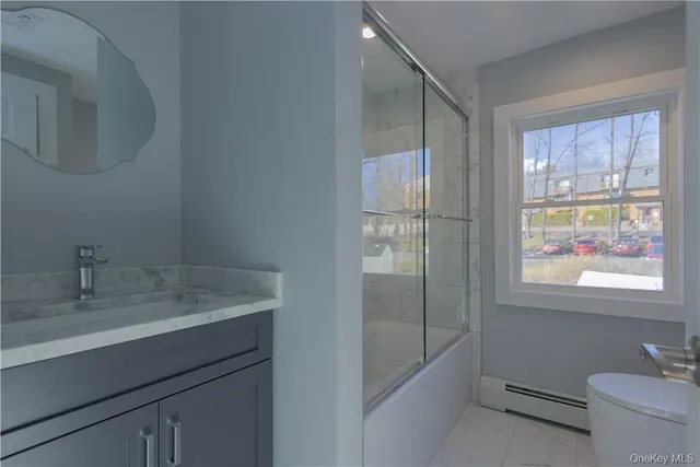 a bathroom with a granite countertop sink a toilet and shower