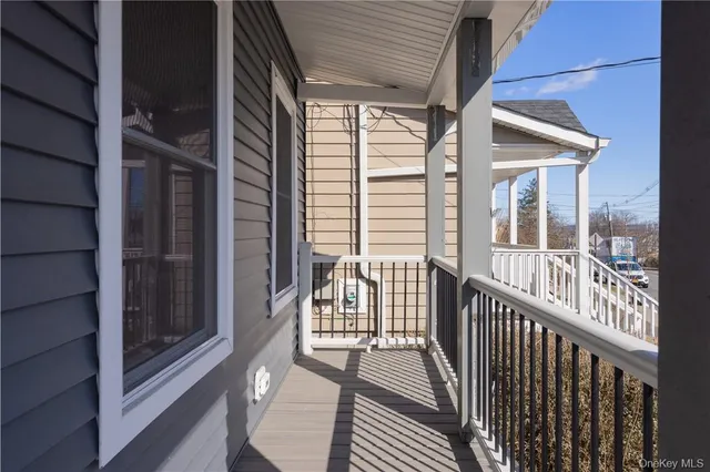 a view of a porch with wooden floor and floor to ceiling window
