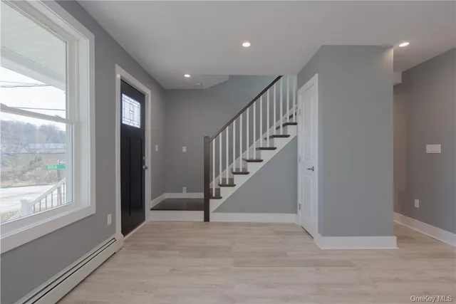a view of entryway and hall with wooden floor
