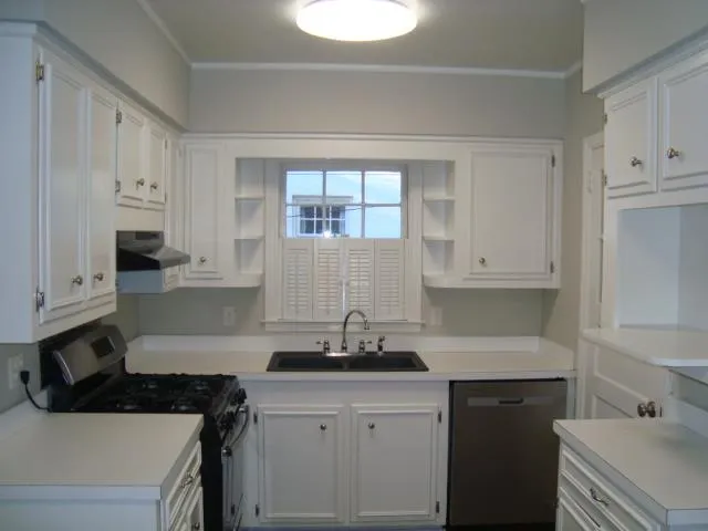 a kitchen with a sink cabinets and window