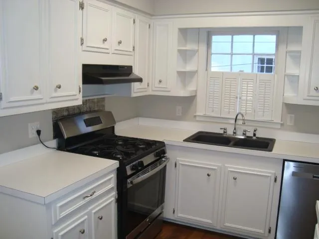 a kitchen with white cabinets and appliances