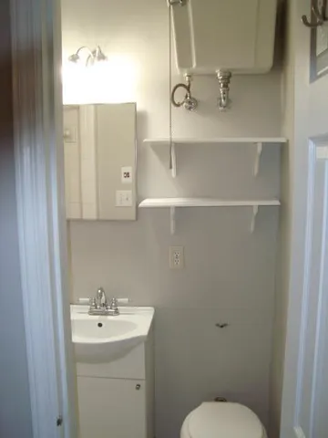 a bathroom with a toilet sink and mirror
