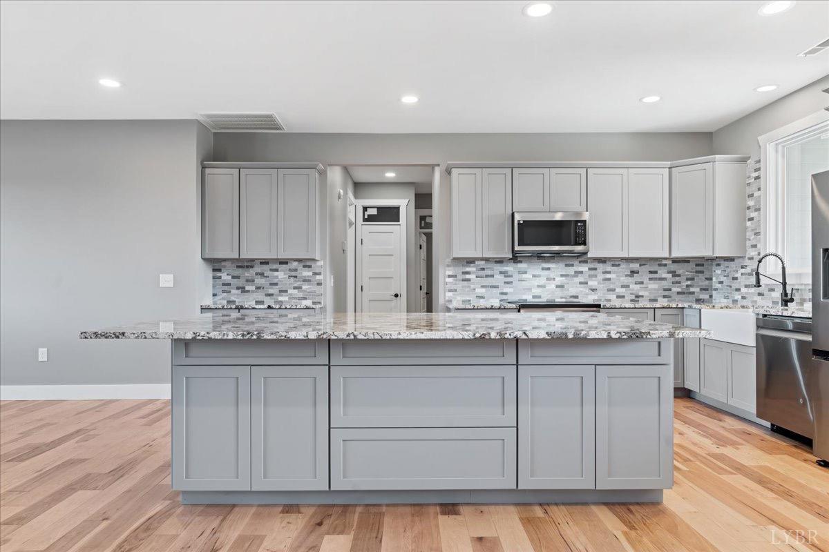 4615 Everett Road Forest, VA 24551 - Photo 15 of 56 a kitchen with kitchen island granite countertop a sink cabinets and stainless steel appliances