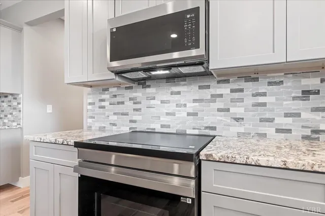 a kitchen with granite countertop white cabinets and a sink