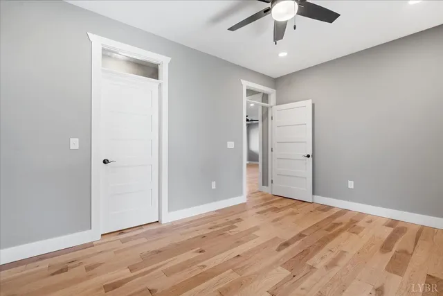 an empty room with a window and a ceiling fan