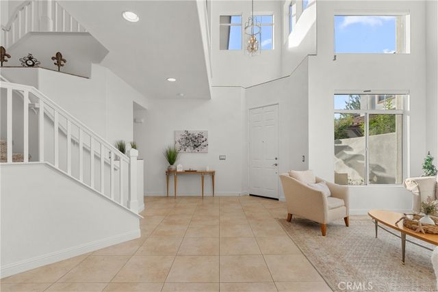 a bedroom with bed and a large mirror next to a window