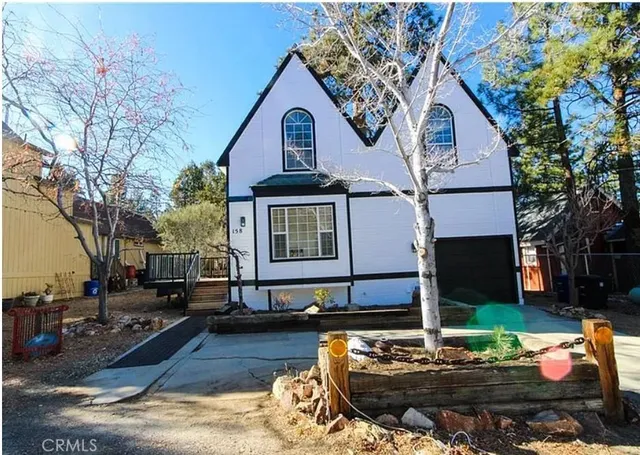 a view of a house with backyard water and a tree