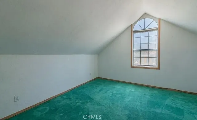 an empty room with windows & cabinet