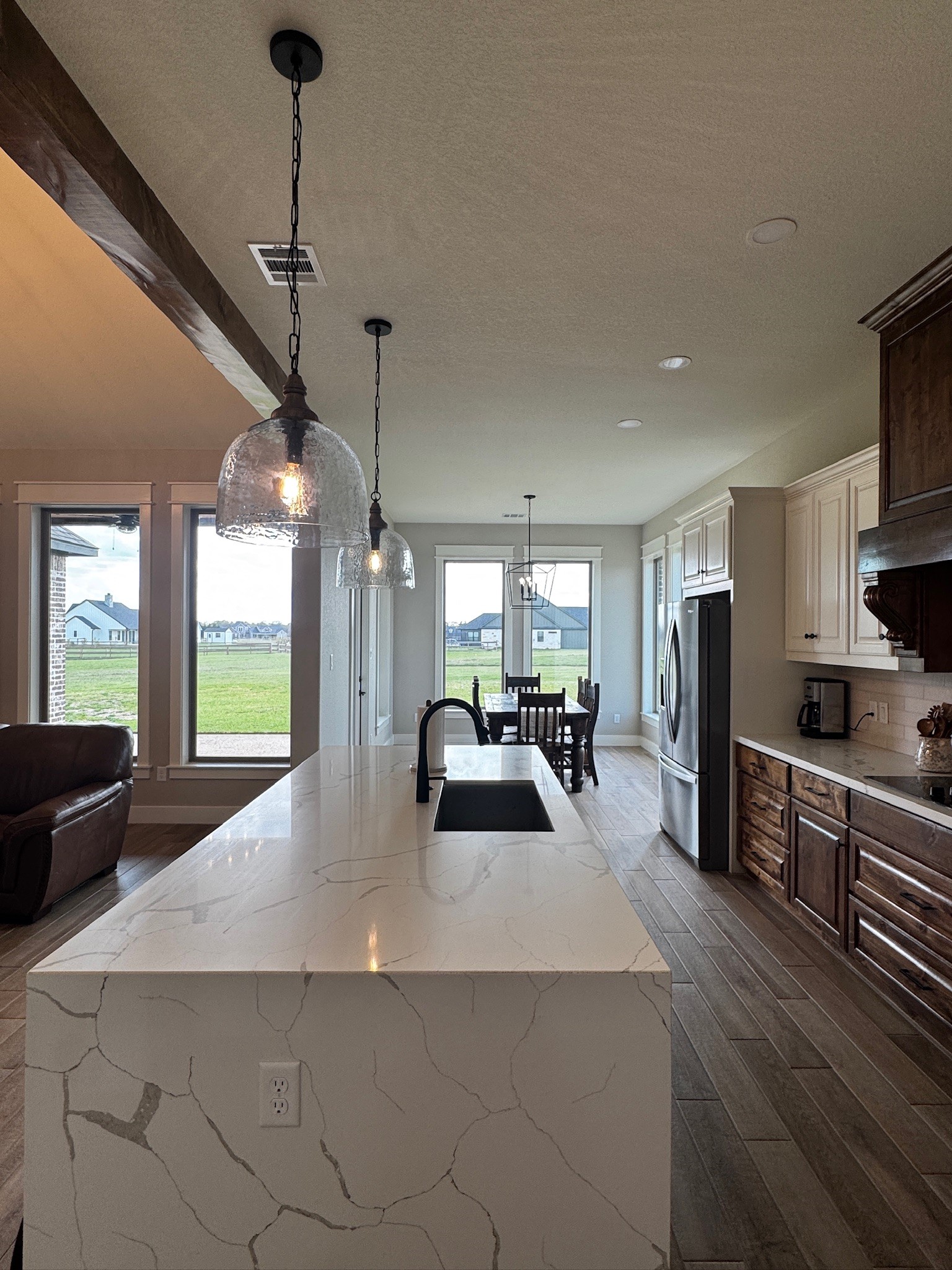 5854 Reliance Ridge Circle Bryan, TX 77808 - Photo 14 of 32 a kitchen with stainless steel appliances kitchen island granite countertop a refrigerator a oven a dining table and chairs with wooden floor