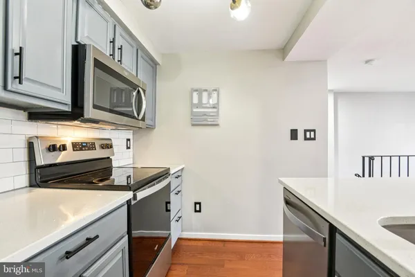 a kitchen with stainless steel appliances white cabinets and a stove top oven