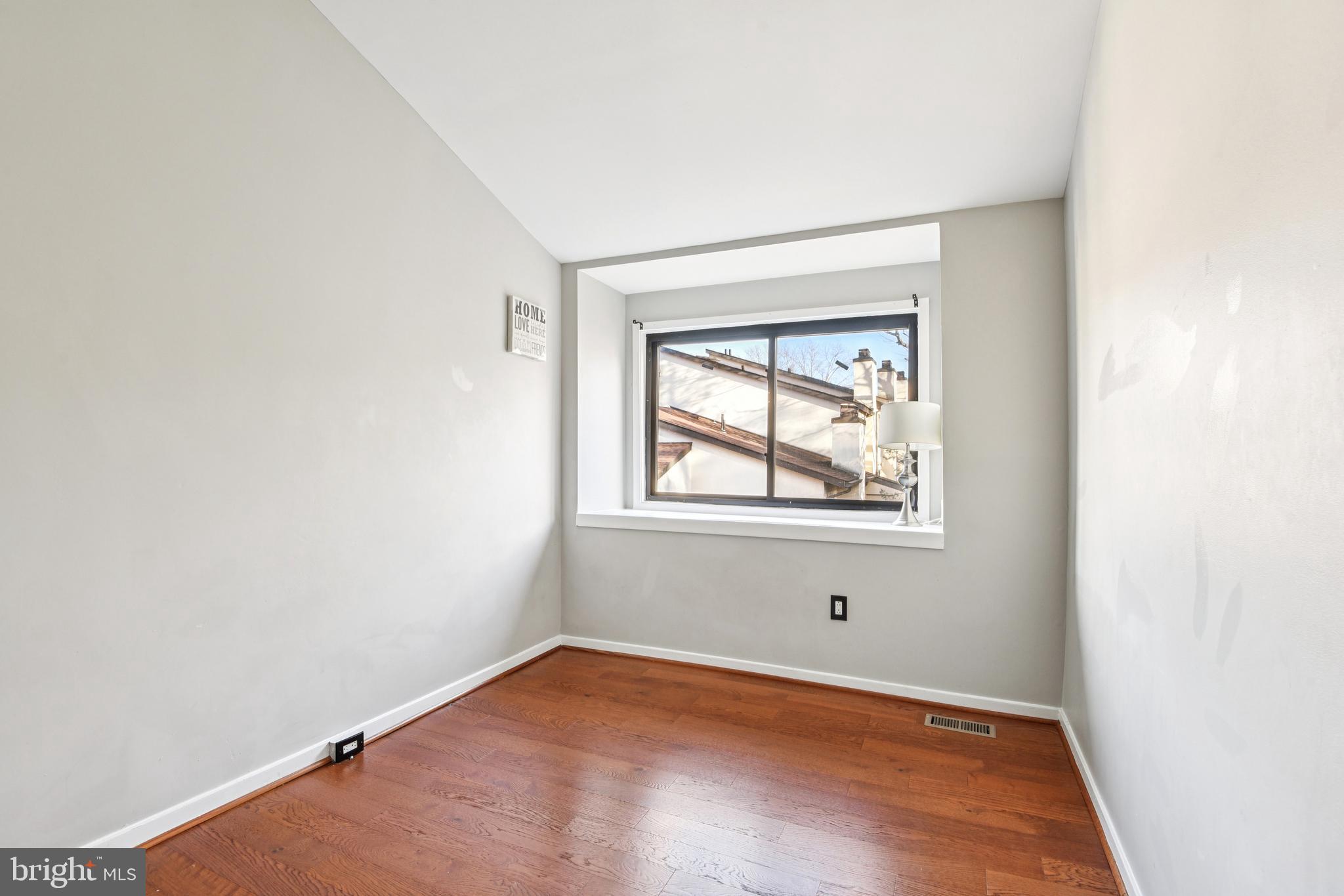 9717 Hellingly Place, Unit 48 Gaithersburg, MD 20886 - Photo 16 of 32 a view of an empty room with wooden floor and a window