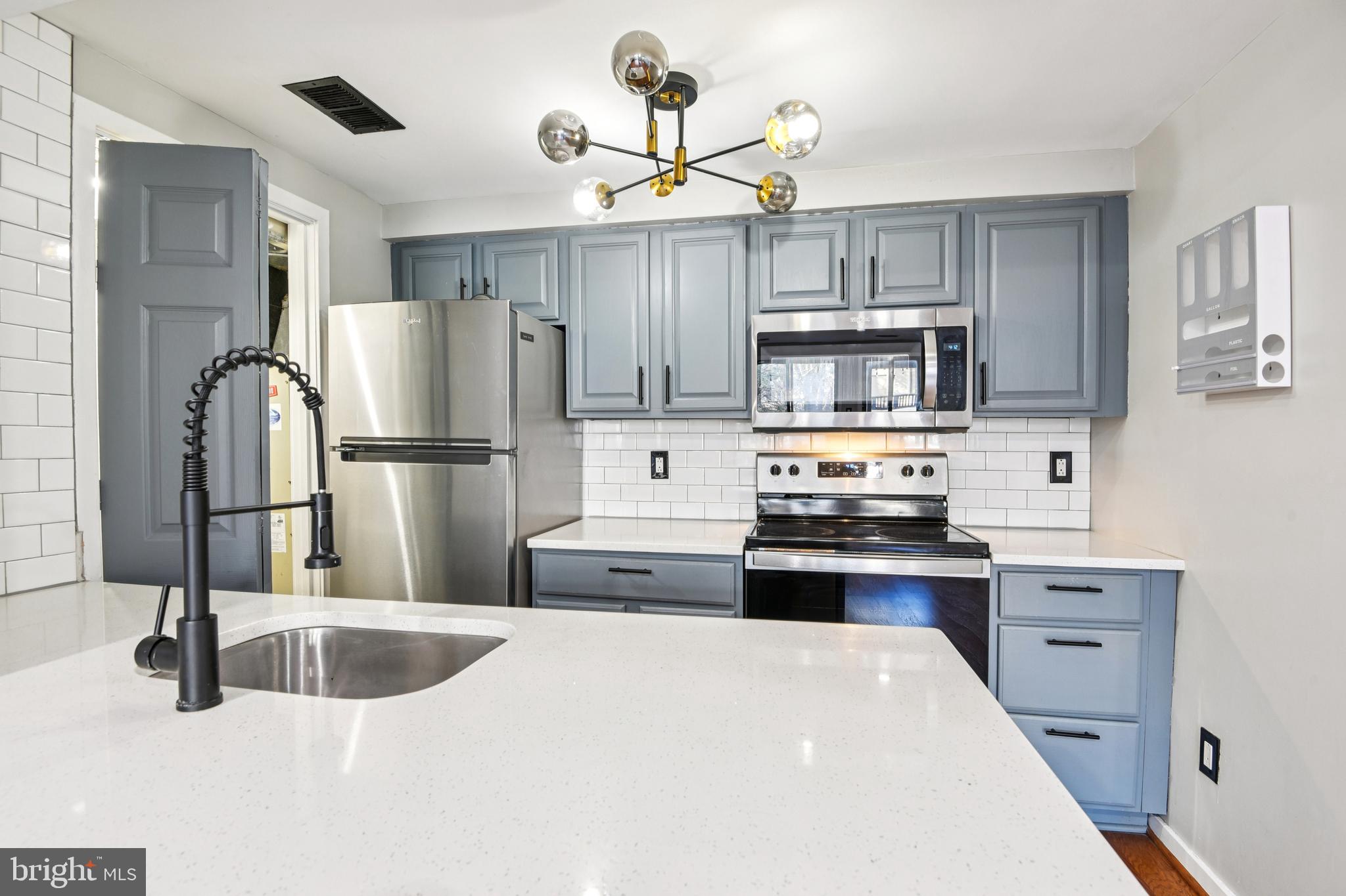 9717 Hellingly Place, Unit 48 Gaithersburg, MD 20886 - Photo 2 of 32 a kitchen with kitchen island a sink appliances and cabinets