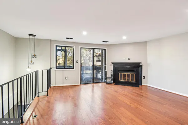 a view of empty room with wooden floor and fireplace