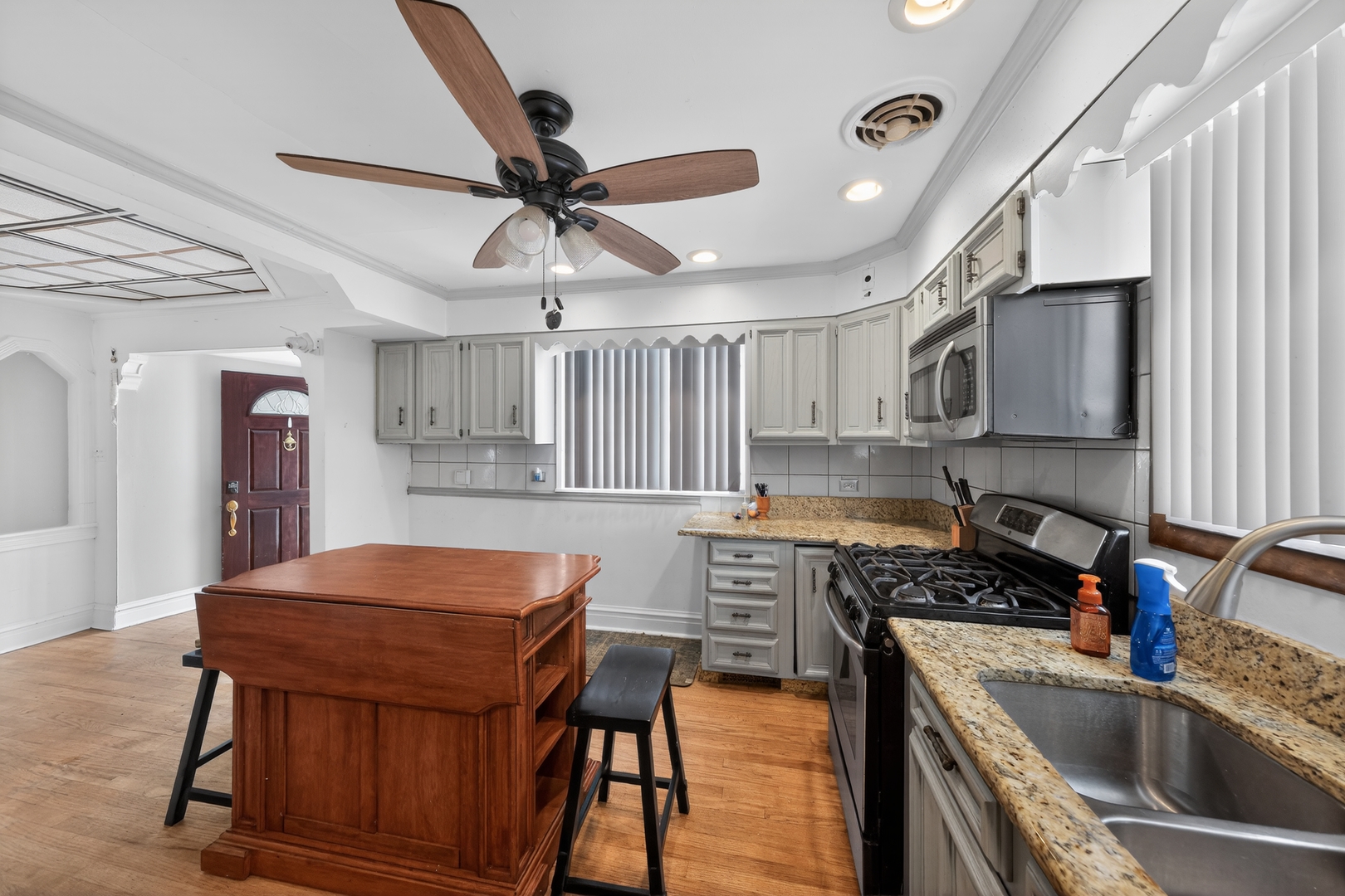 7315 Arcadia Street Morton Grove, IL 60053 - Photo 8 of 15 a kitchen with stainless steel appliances a stove a sink dishwasher a microwave oven with a dining table and chairs