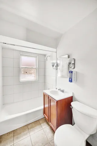 a bathroom with a granite countertop toilet sink and mirror