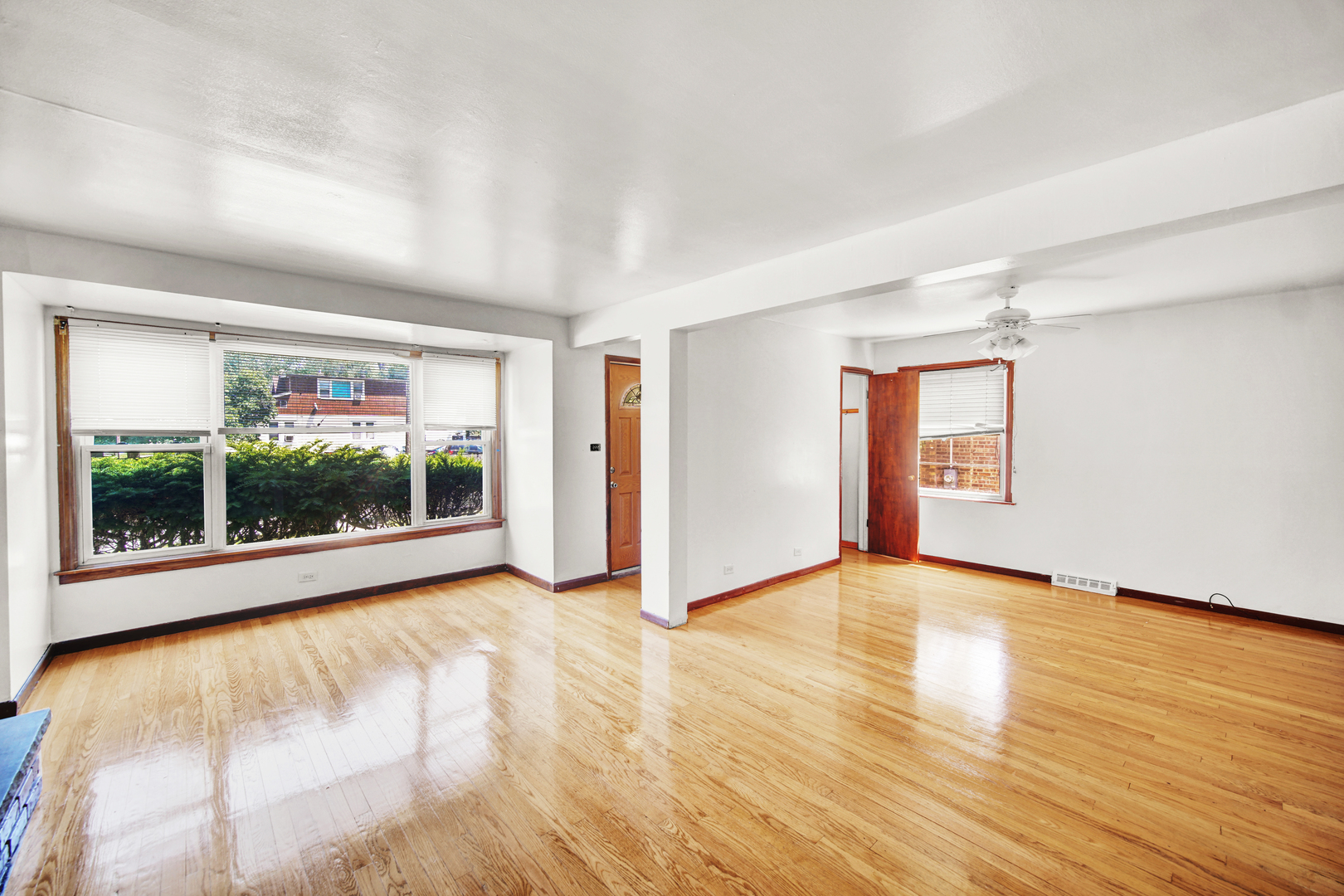 14528 Grant Street Dolton, IL 60419 - Photo 2 of 26 a view of an empty room with wooden floor and a window