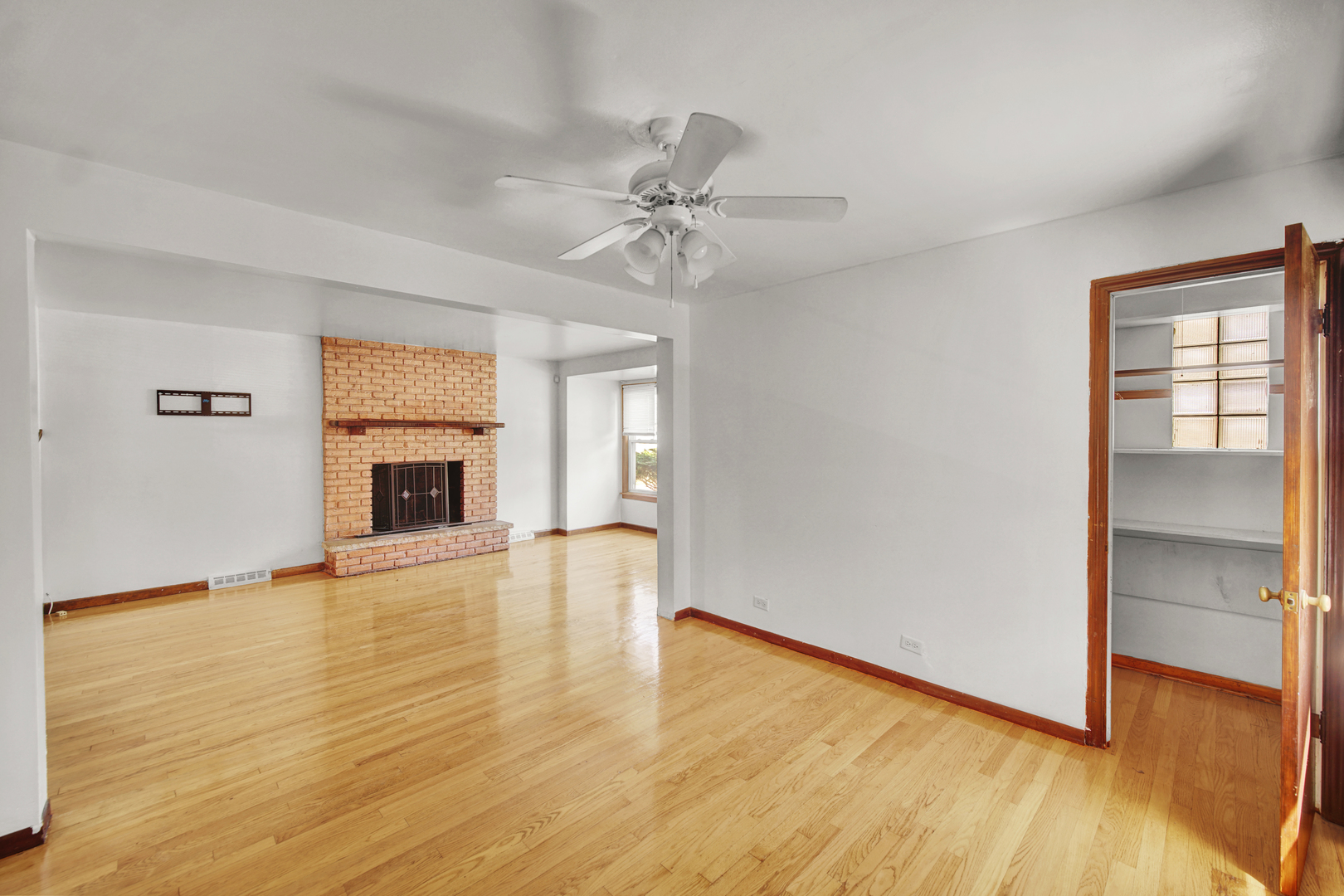 14528 Grant Street Dolton, IL 60419 - Photo 4 of 26 an empty room with wooden floor fireplace and windows