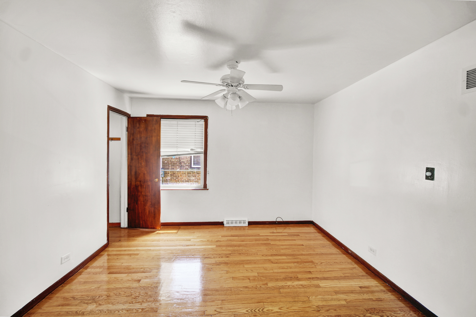 14528 Grant Street Dolton, IL 60419 - Photo 5 of 26 wooden floor in an empty room with a window