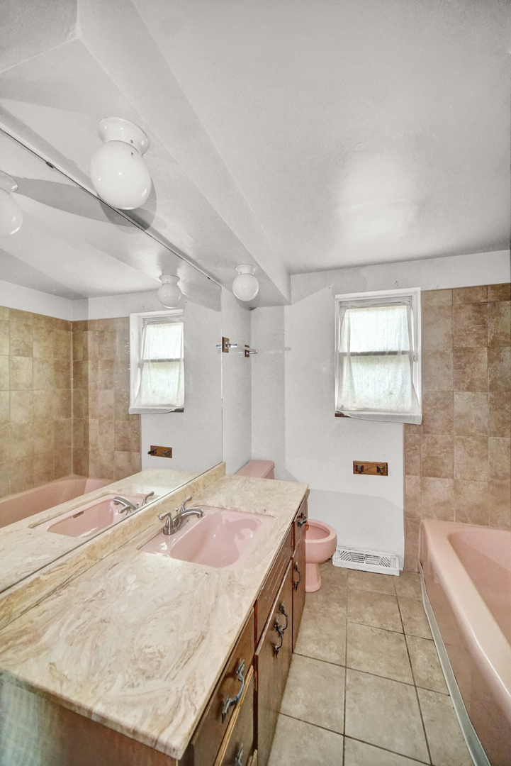14528 Grant Street Dolton, IL 60419 - Photo 8 of 26 a spacious bathroom with a granite countertop sink a toilet a mirror and bathtub