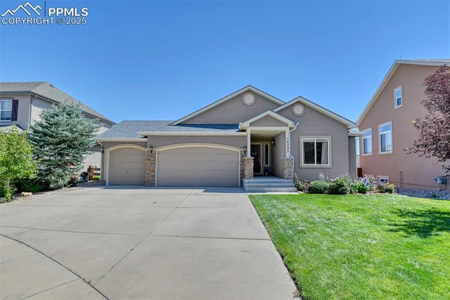 a front view of a house with a garden and garage