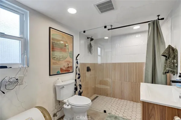 a kitchen with a stove a sink cabinets and wooden floor