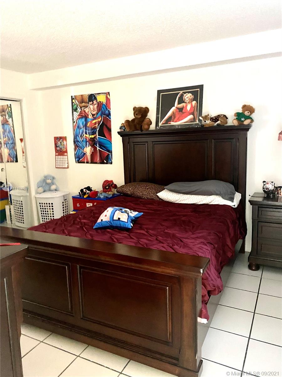 11790 Southwest 18th Street, Unit 1073 Miami, FL 33175 - Photo 13 of 18 a bedroom with a bed and cabinets