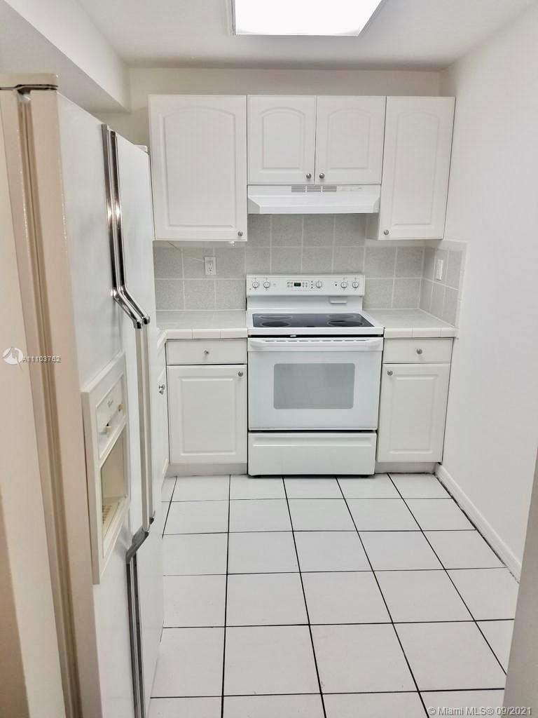 11790 Southwest 18th Street, Unit 1073 Miami, FL 33175 - Photo 10 of 18 a kitchen with a stove a refrigerator and cabinets