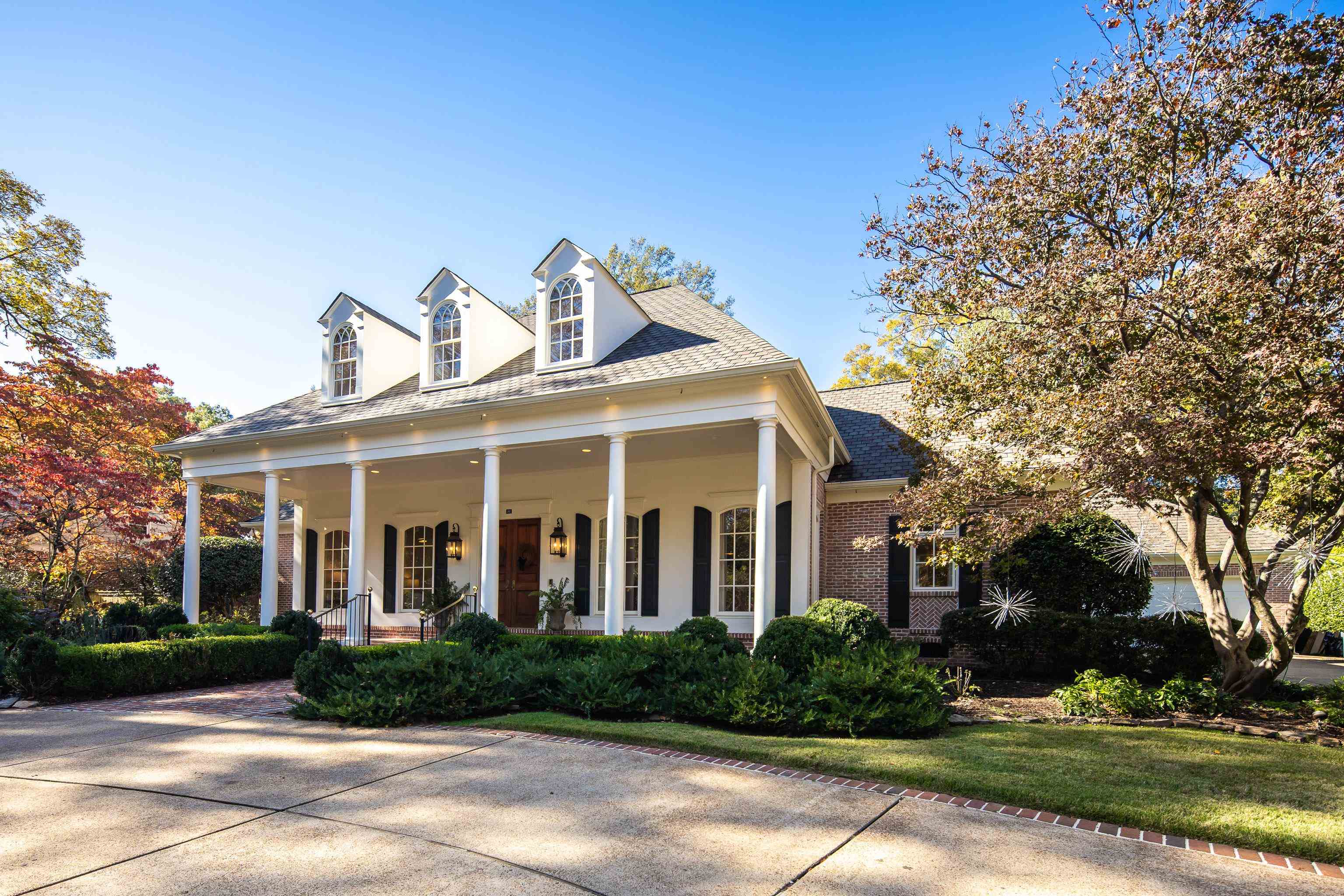View of front facade featuring a porch, brick siding, and a front lawn
