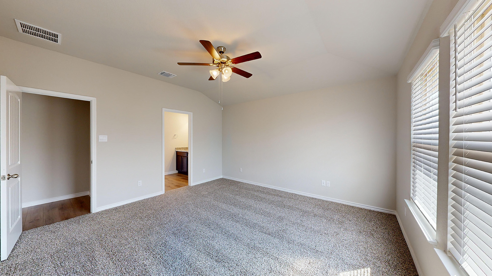 404 Creekfall Road Burnet, TX 78611 - Photo 9 of 23 Unfurnished bedroom with light colored carpet, ensuite bathroom, lofted ceiling, ceiling fan, and multiple windows