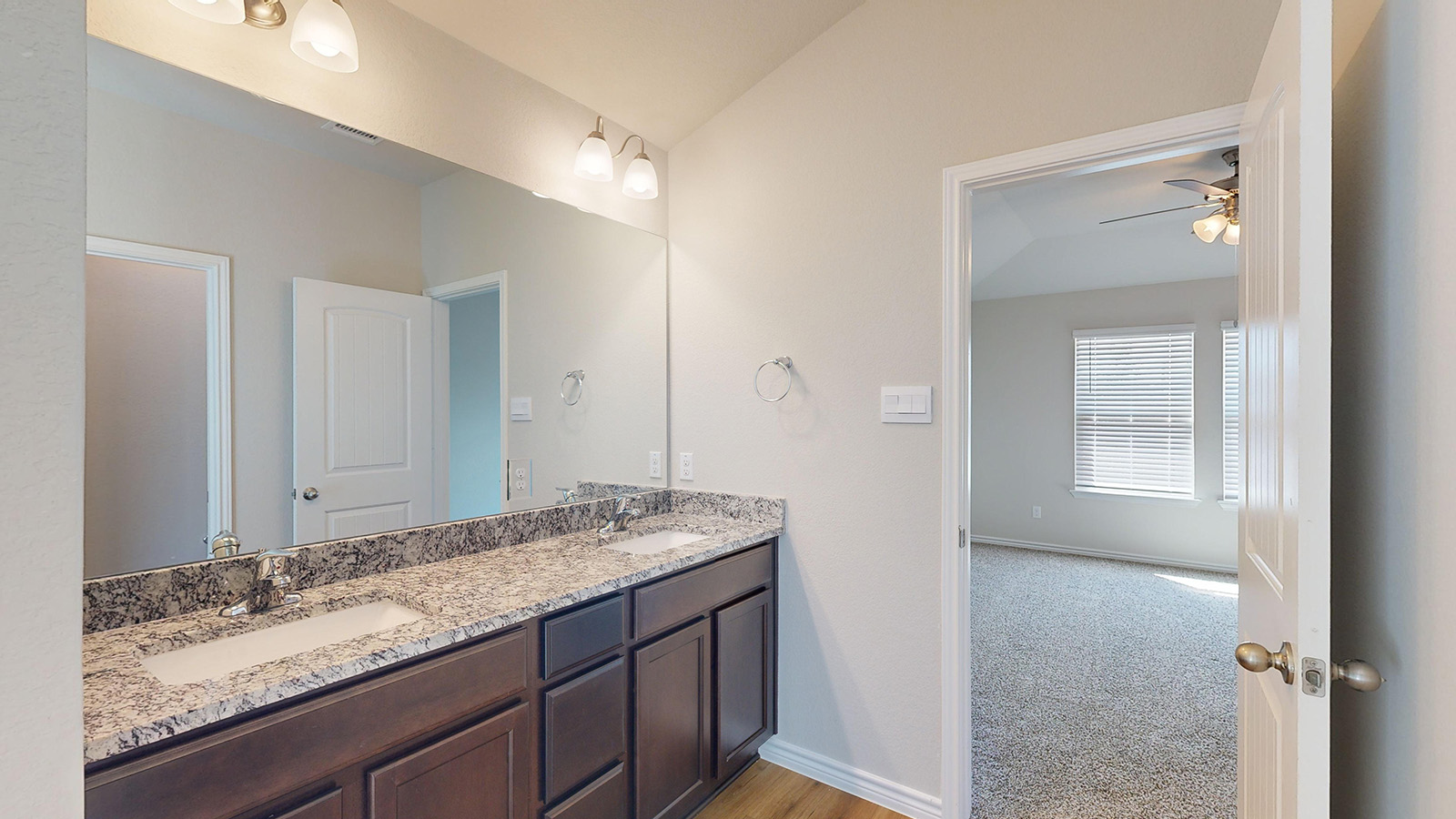 404 Creekfall Road Burnet, TX 78611 - Photo 14 of 23 Bathroom with double vanity, ceiling fan, light carpet, and vaulted ceiling