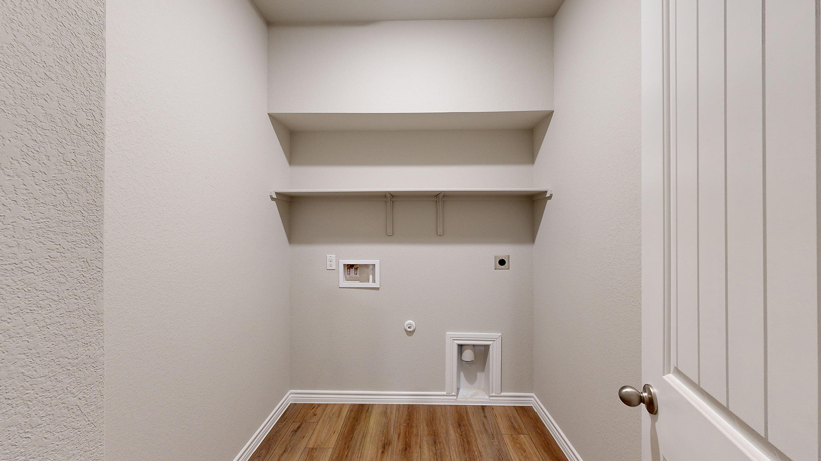 404 Creekfall Road Burnet, TX 78611 - Photo 21 of 23 Laundry room featuring hookup for a gas dryer, light wood-style floors, hookup for a washing machine, hookup for an electric dryer, and a textured wall