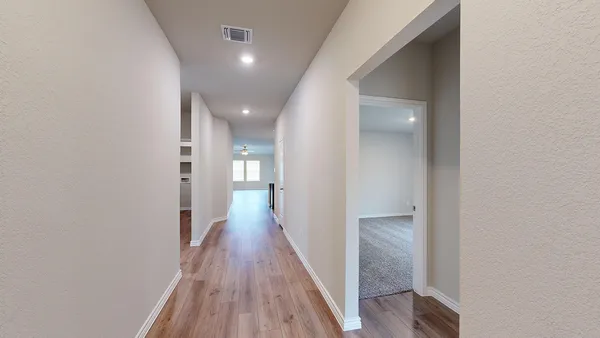 a view of a hallway with wooden floor