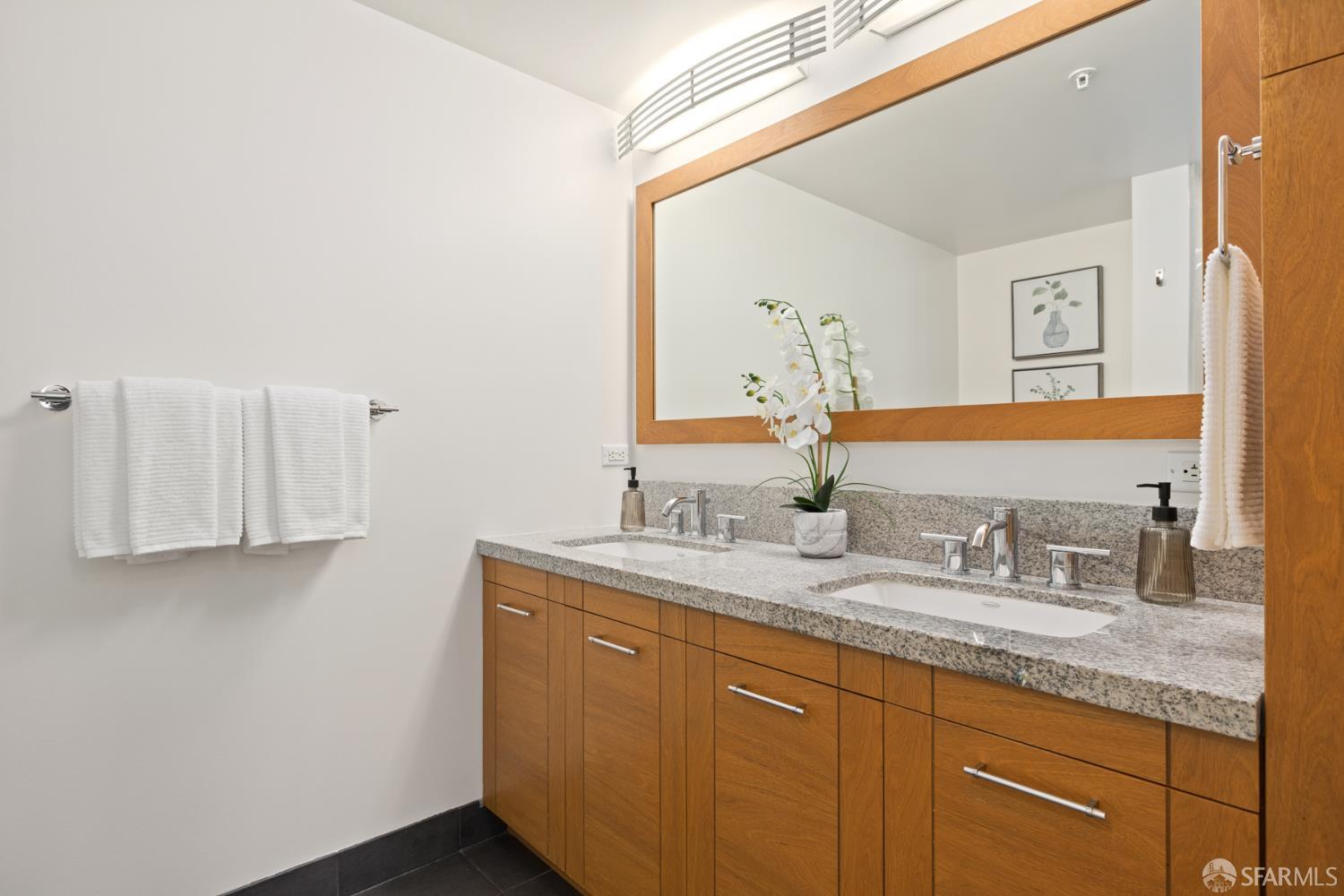 177 Townsend Street, Unit 728 San Francisco, CA 94107 - Photo 15 of 39 a bathroom with a granite countertop sink and a mirror