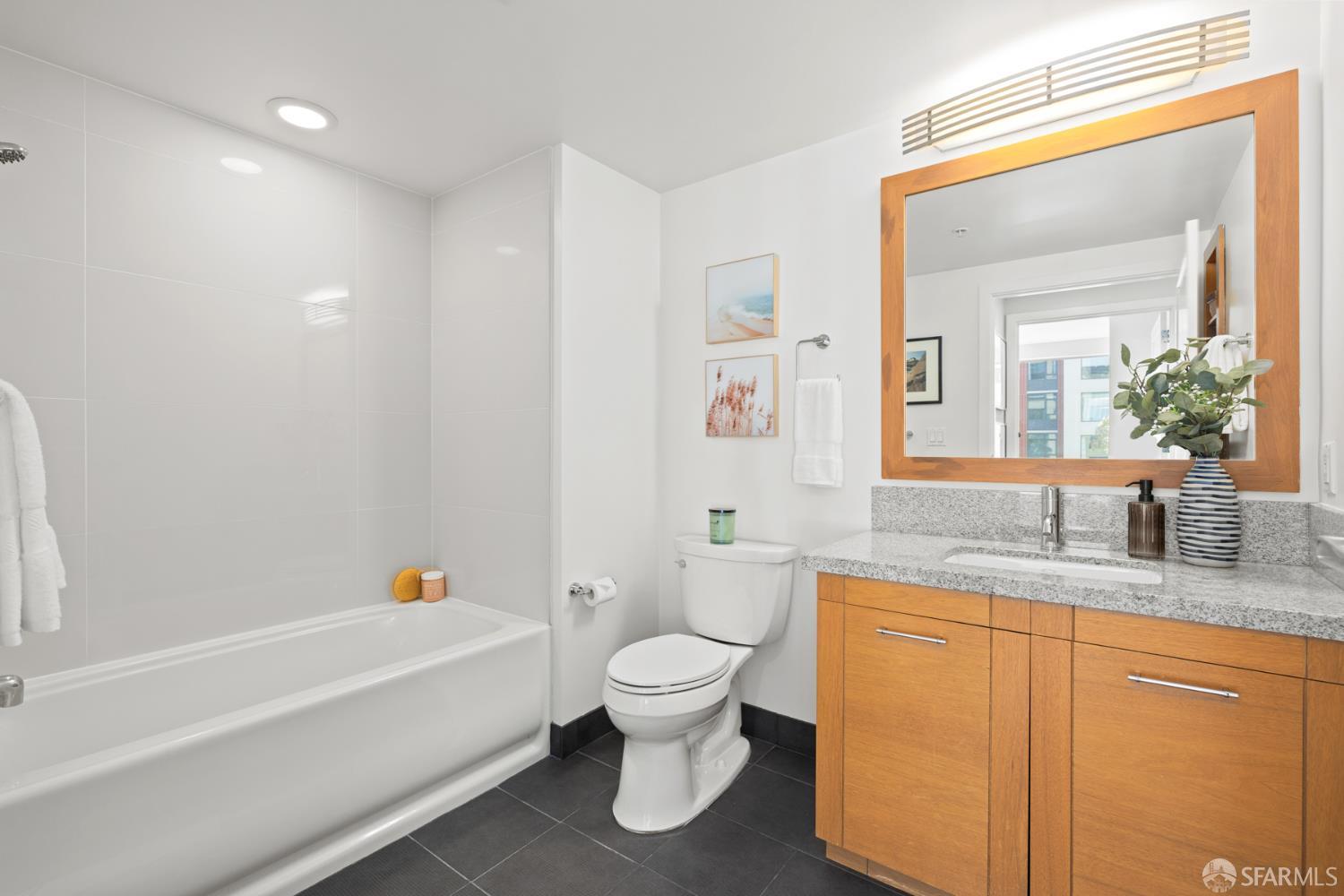 177 Townsend Street, Unit 728 San Francisco, CA 94107 - Photo 19 of 39 a bathroom with a granite countertop sink a toilet and a bathtub
