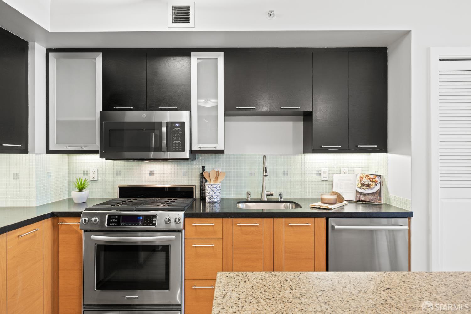 177 Townsend Street, Unit 728 San Francisco, CA 94107 - Photo 6 of 39 a kitchen with stainless steel appliances granite countertop a sink stove and microwave