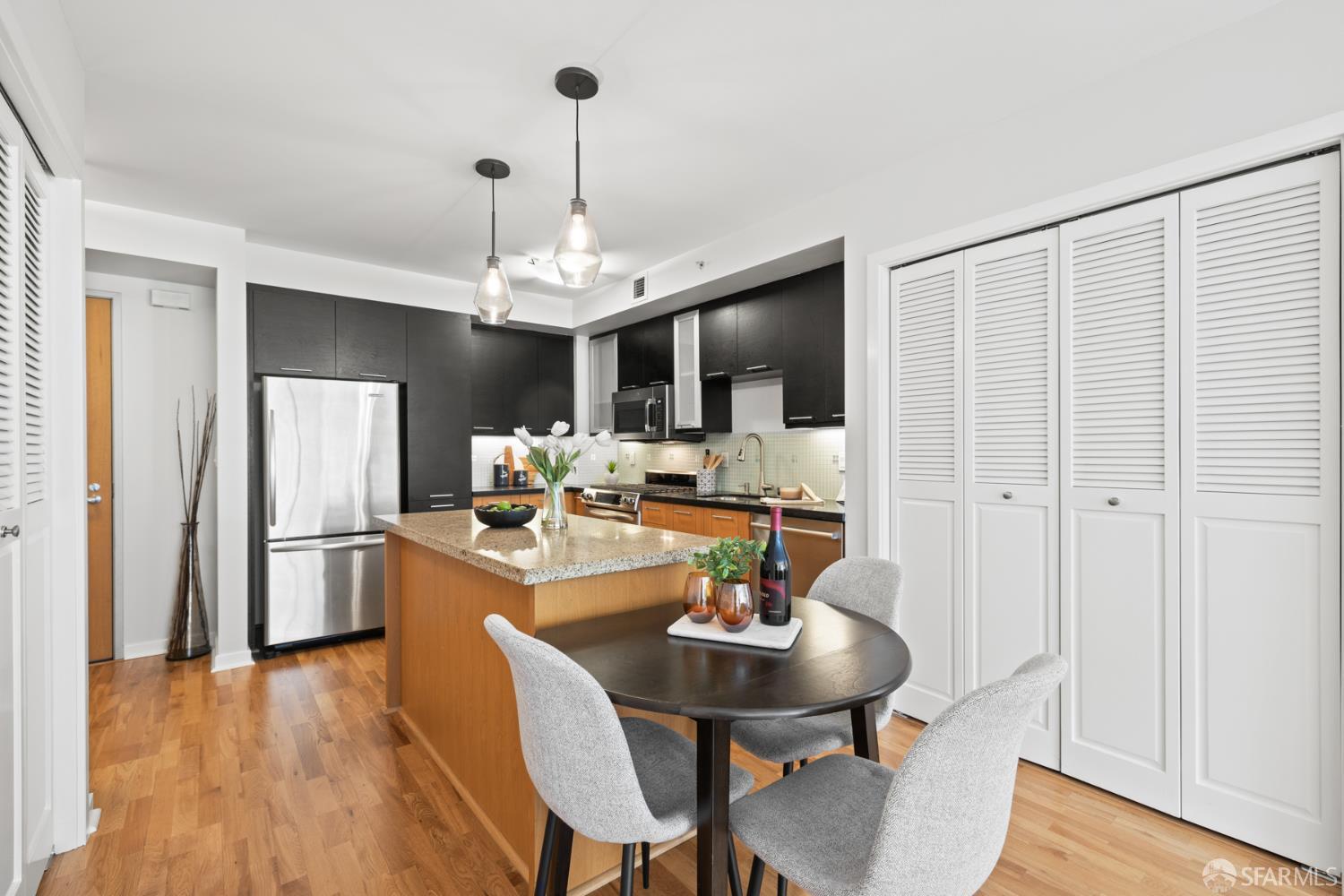 177 Townsend Street, Unit 728 San Francisco, CA 94107 - Photo 8 of 39 a kitchen with kitchen island a dining table chairs stainless steel appliances and cabinets