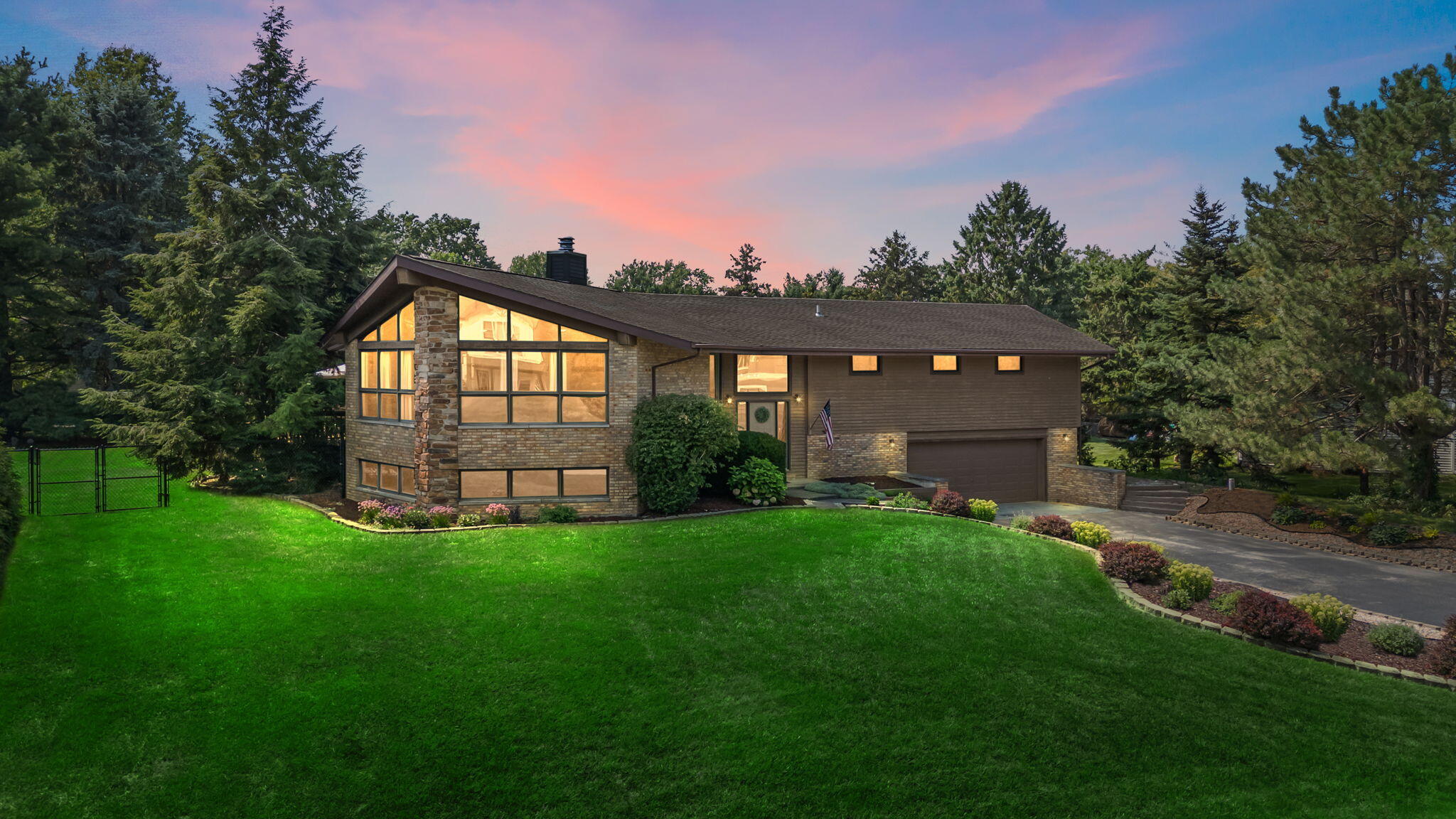 a view of a big house with a big yard and large trees