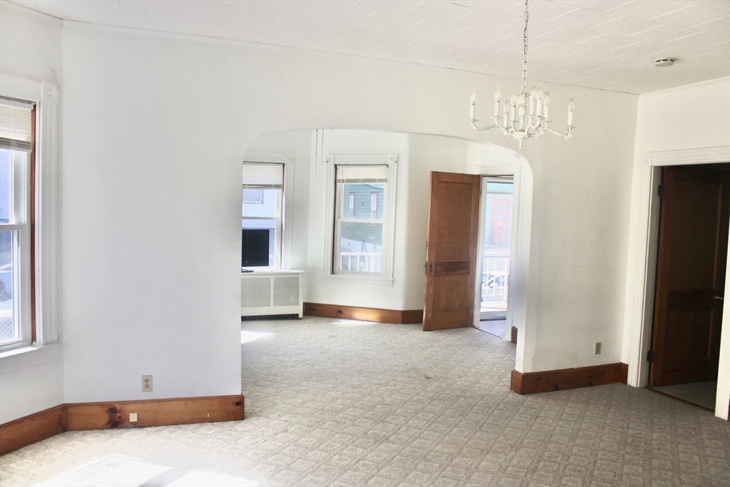 136 Horton Street, Unit 1 Fall River, MA 02723 - Photo 4 of 17 an empty room with windows and entrance