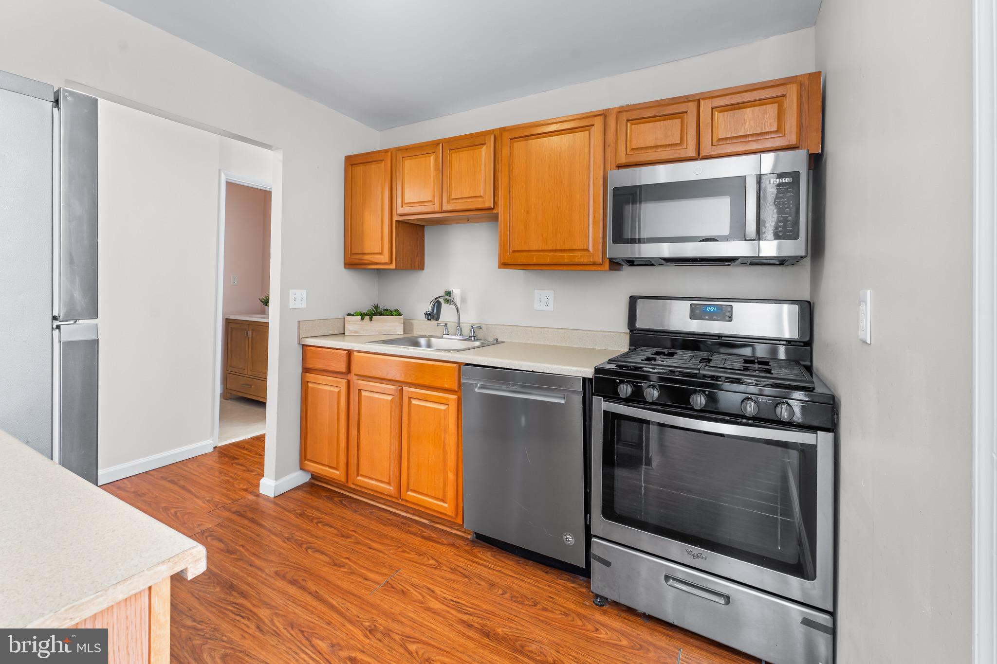 3340 Huntley Square Drive, Unit A Temple Hills, MD 20748 - Photo 17 of 19 a kitchen with stainless steel appliances a stove a sink and a microwave