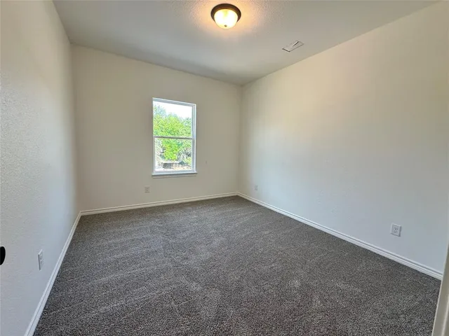 an empty room with windows and mirror