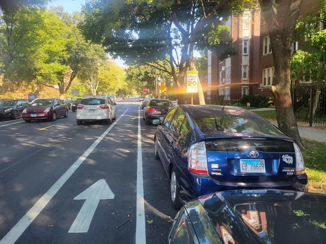 a view of a street with parked cars