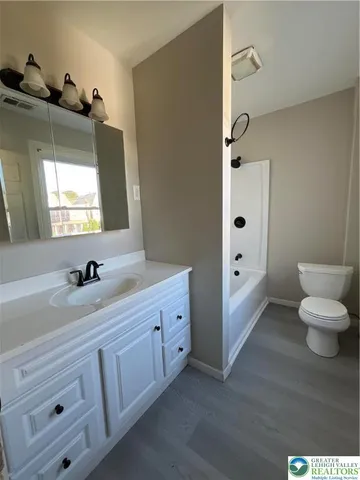 a bathroom with a double vanity sink toilet and mirror