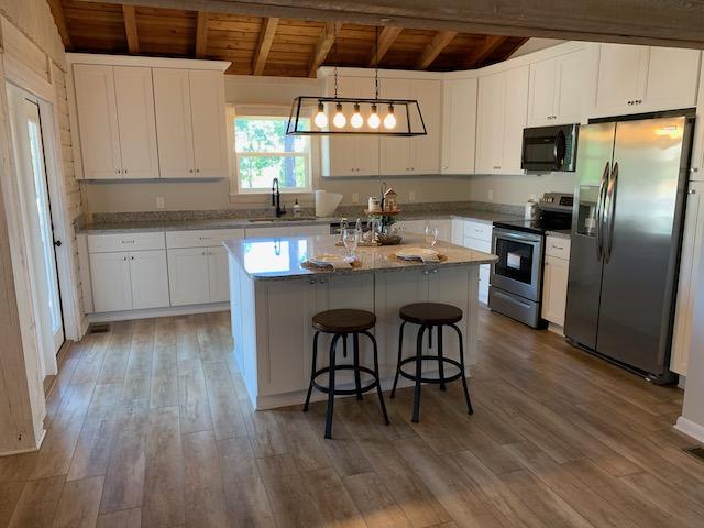 421 Ridge Road Santa Rosa Beach, FL 32459 - Photo 8 of 29 a kitchen with stainless steel appliances a dining table chairs microwave and sink