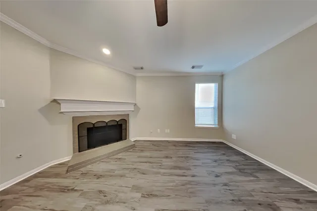 wooden floor fireplace and windows in an empty room
