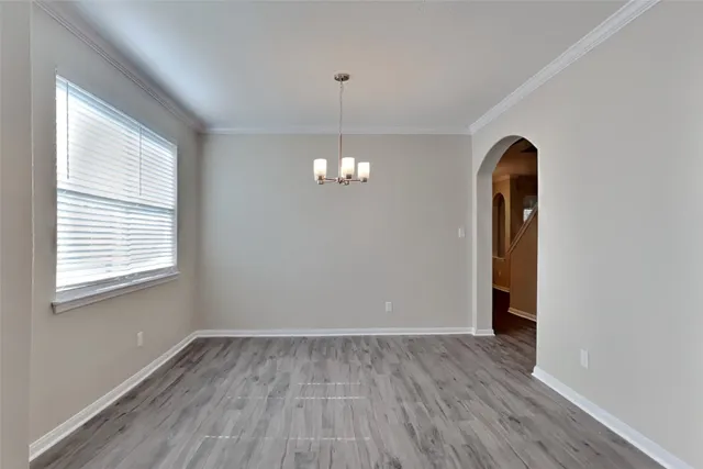 a view of a room with wooden floor and chandelier