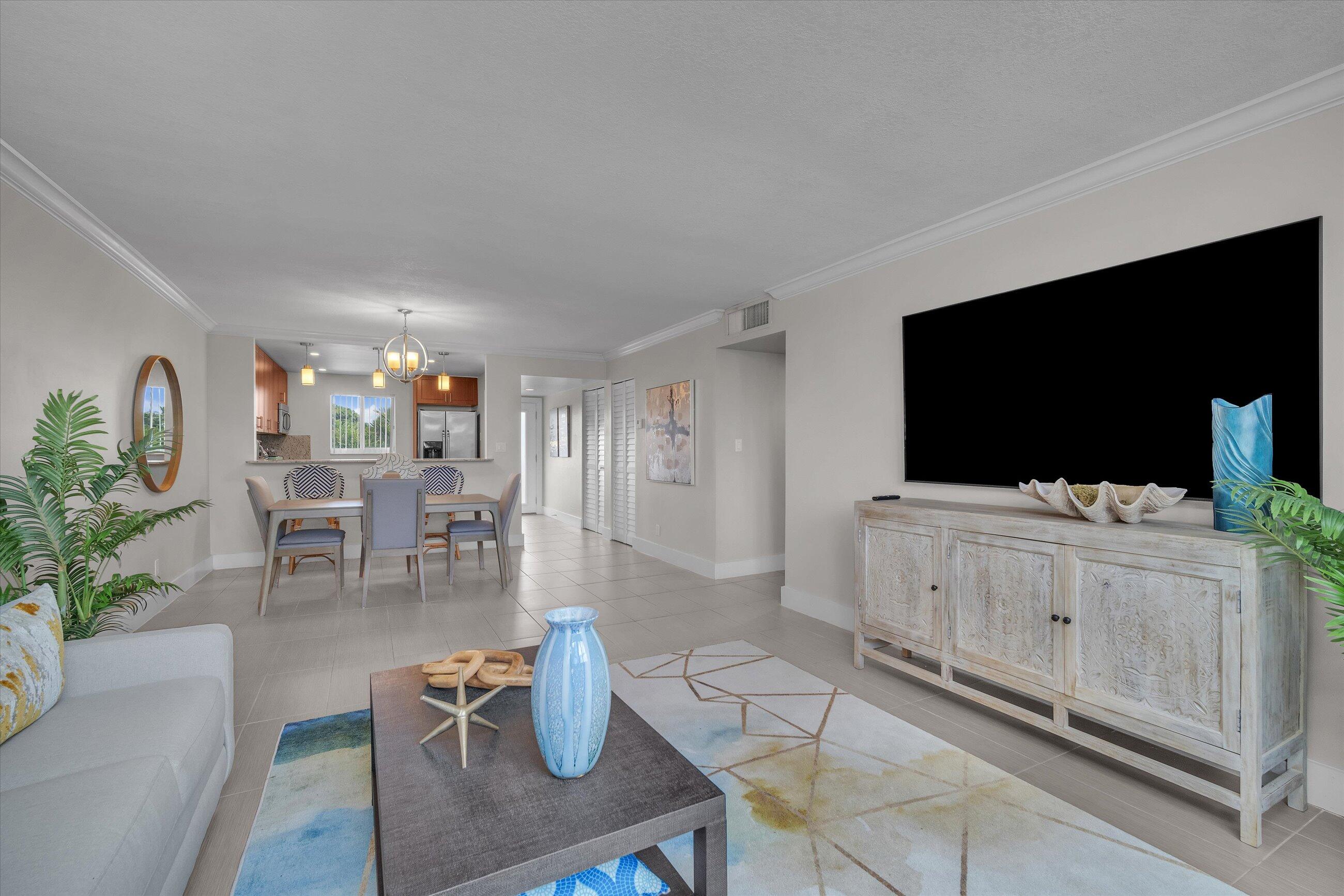 601 North Ocean Boulevard, Unit 203 Boca Raton, FL 33432 - Photo 12 of 20 a living room with furniture and a flat screen tv