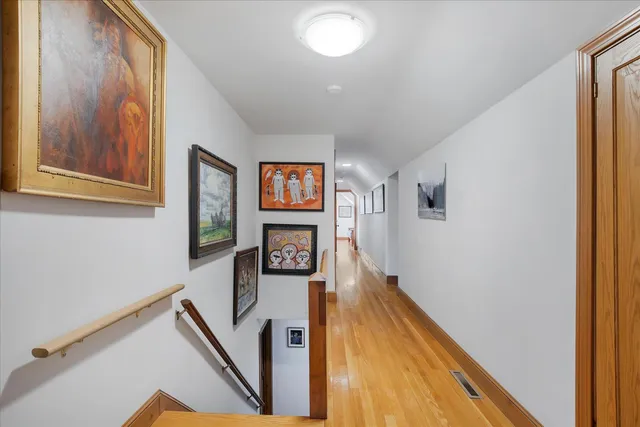 a bedroom with a bed and a dresser with wooden floor