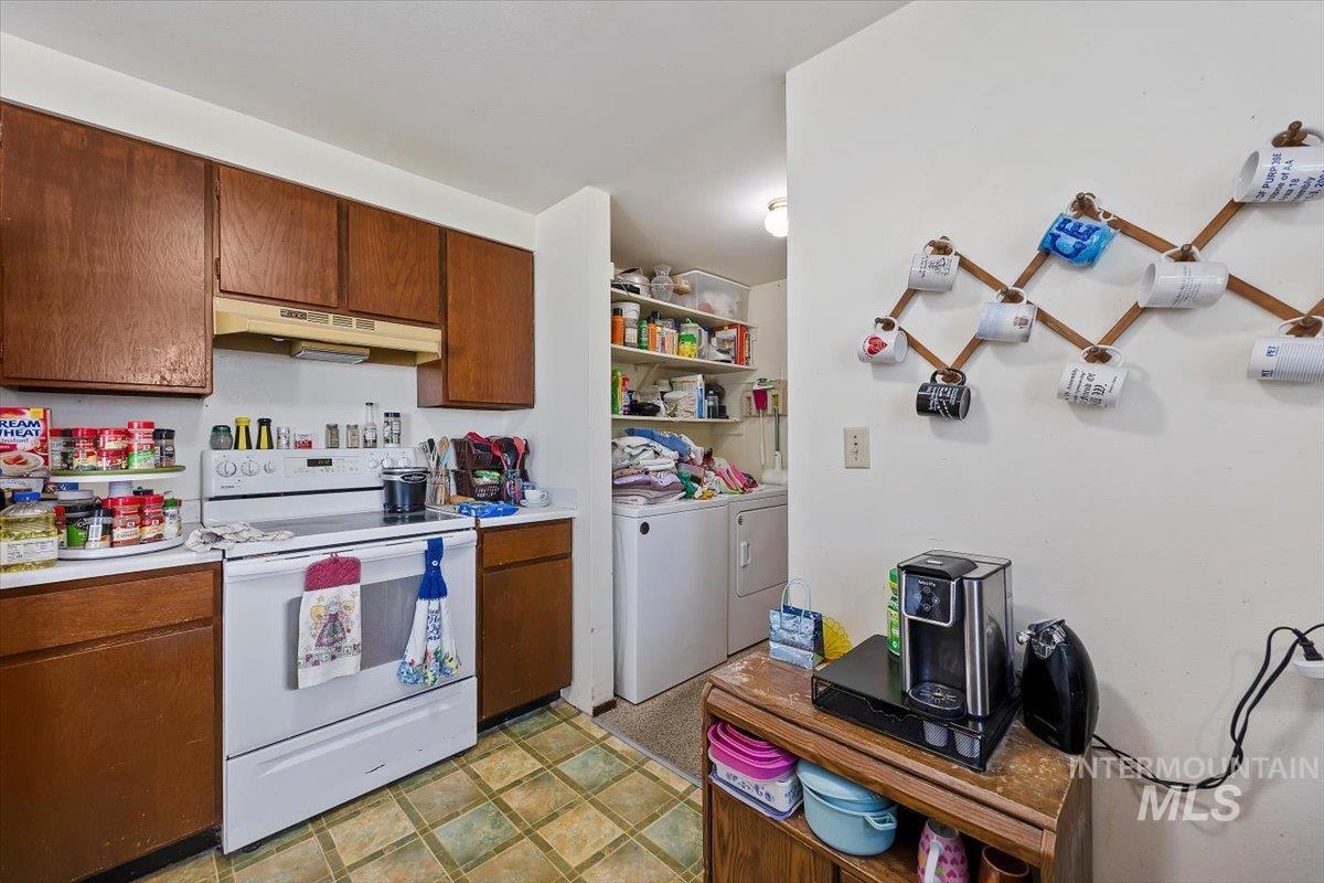 125 Sunset Circle Buhl, ID 83316 - Photo 9 of 17 Kitchen with white electric stove, light countertops, wood finish cabinetry, and independent washer and dryer