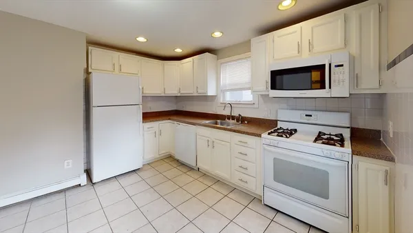 a kitchen with white cabinets and white appliances